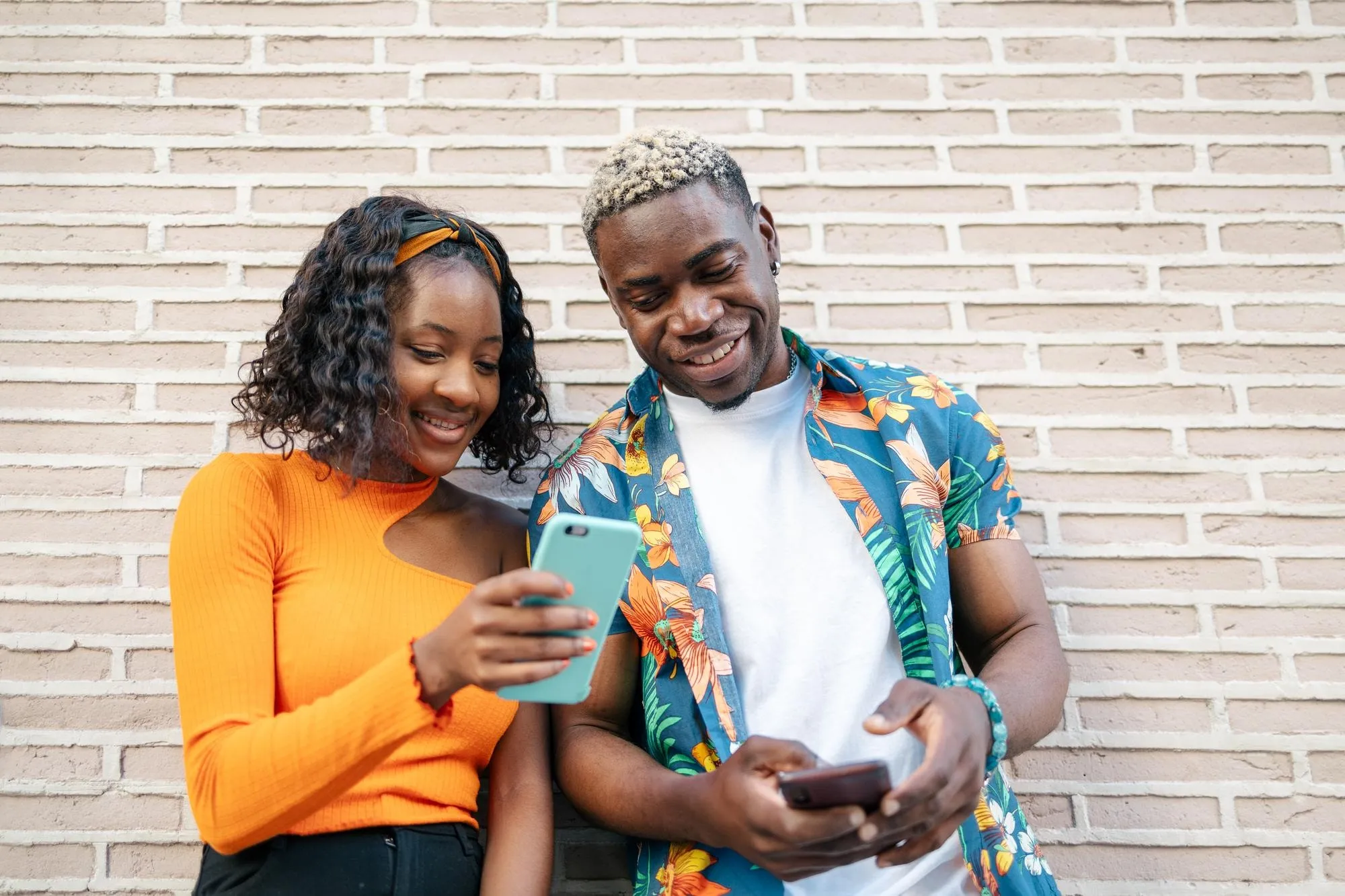 Two friends laughing at something on a phone